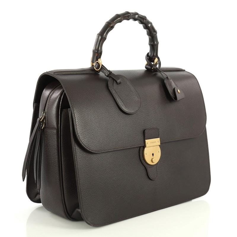 This Gucci Bamboo Top Handle Briefcase Leather, crafted from brown leather, features a bamboo top handle, frontal with lock closure, and aged gold-tone hardware. Its zip closure opens to a brown microfiber with side zip and slip pockets. 

Estimated