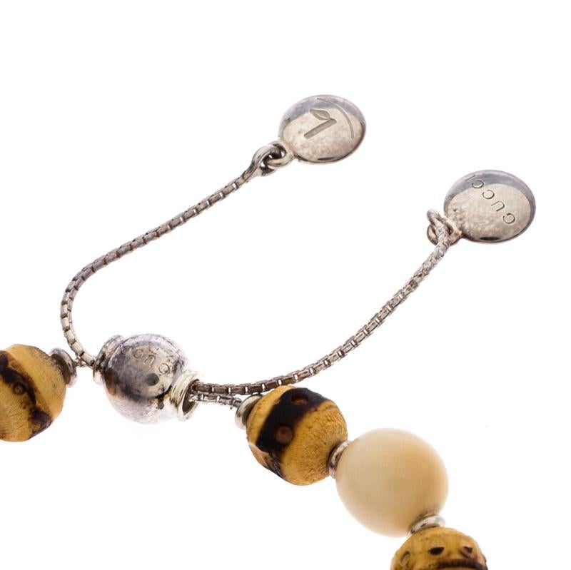 Simplicity and fashion combine to form this exquisite Gucci bracelet just for you. Made from silver, the bracelet features a string of wood beads and an adjustable closure. Minimal and comfortable to wear, this piece will make a fine