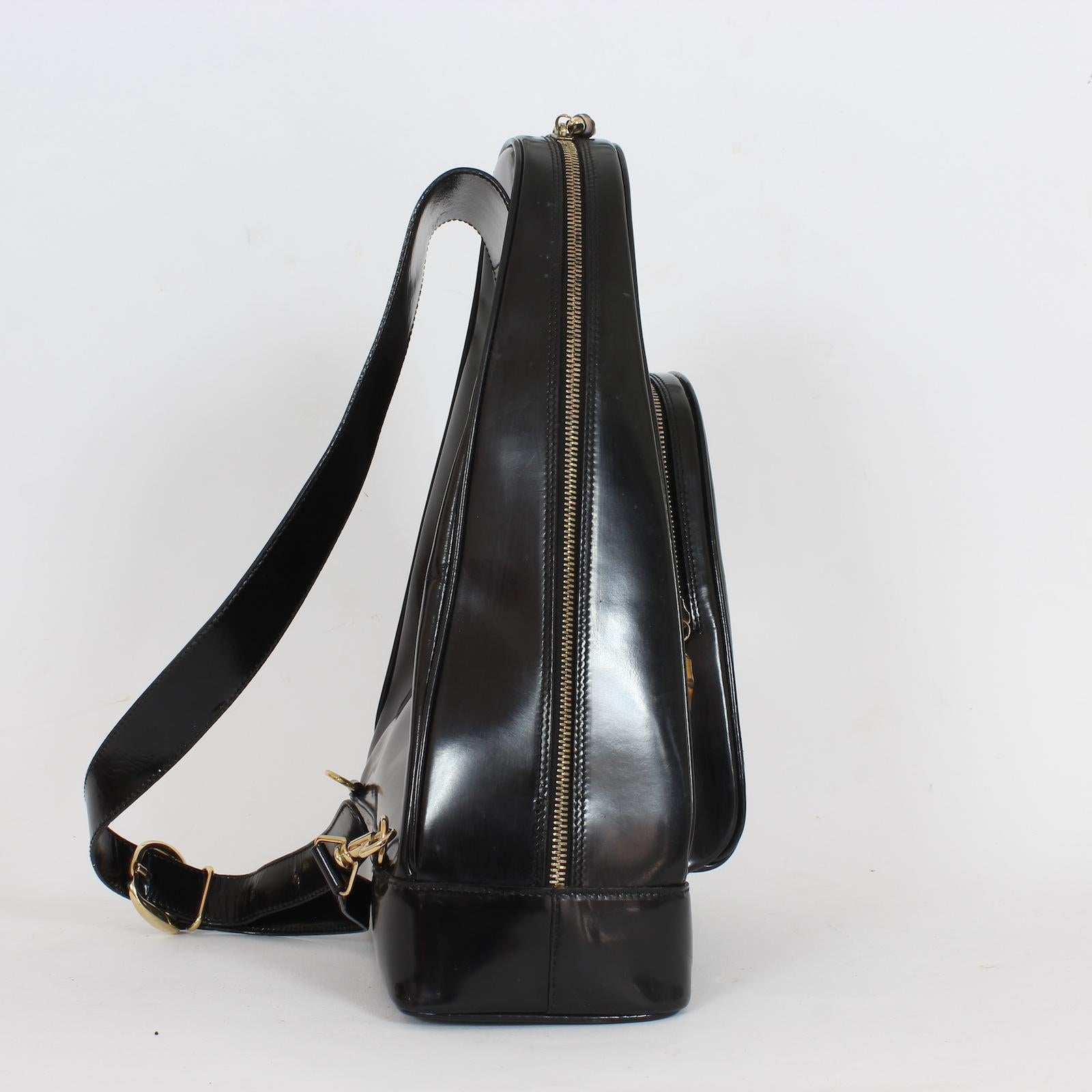 Realizzata in pelle verniciata di alta qualità e caratterizzata dagli iconici dettagli in bambù di Gucci, questa borsa zaino vintage degli anni '90 è allo stesso tempo elegante e funzionale. Con una chiusura sicura con zip e due ampi scomparti, è