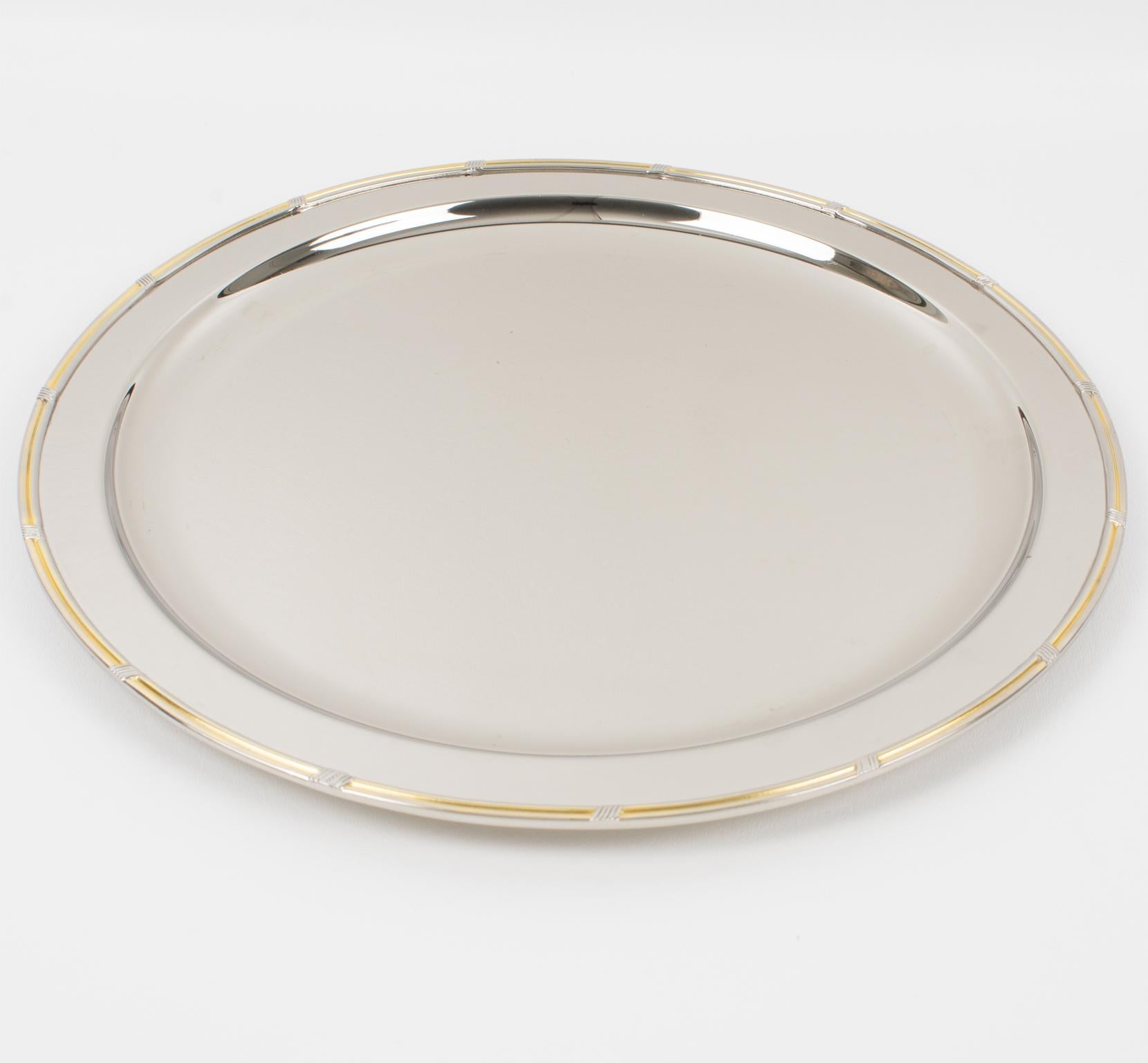 Gucci, Italia, fabricó esta lujosa bandeja de bar de metal plateado, hacia 1980. Este accesorio de bar tiene un diseño elegante y modernista. Tiene una forma redondeada con un borde elevado y está hecho de un metal plateado con una decoración de