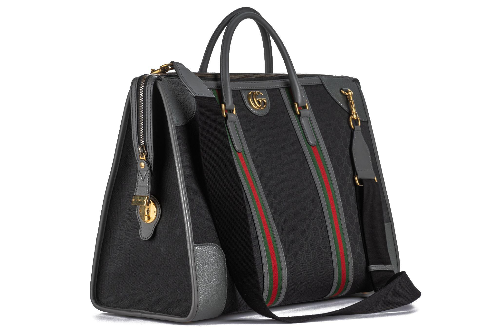 This Gucci Weekender Bag in black GG canvas and gold-tone hardware
features leather trim and rolled handles and a single adjustable shoulder strap. 
The top open up to canvas lining and two interior pockets with a zip closure at top. Comes with 2