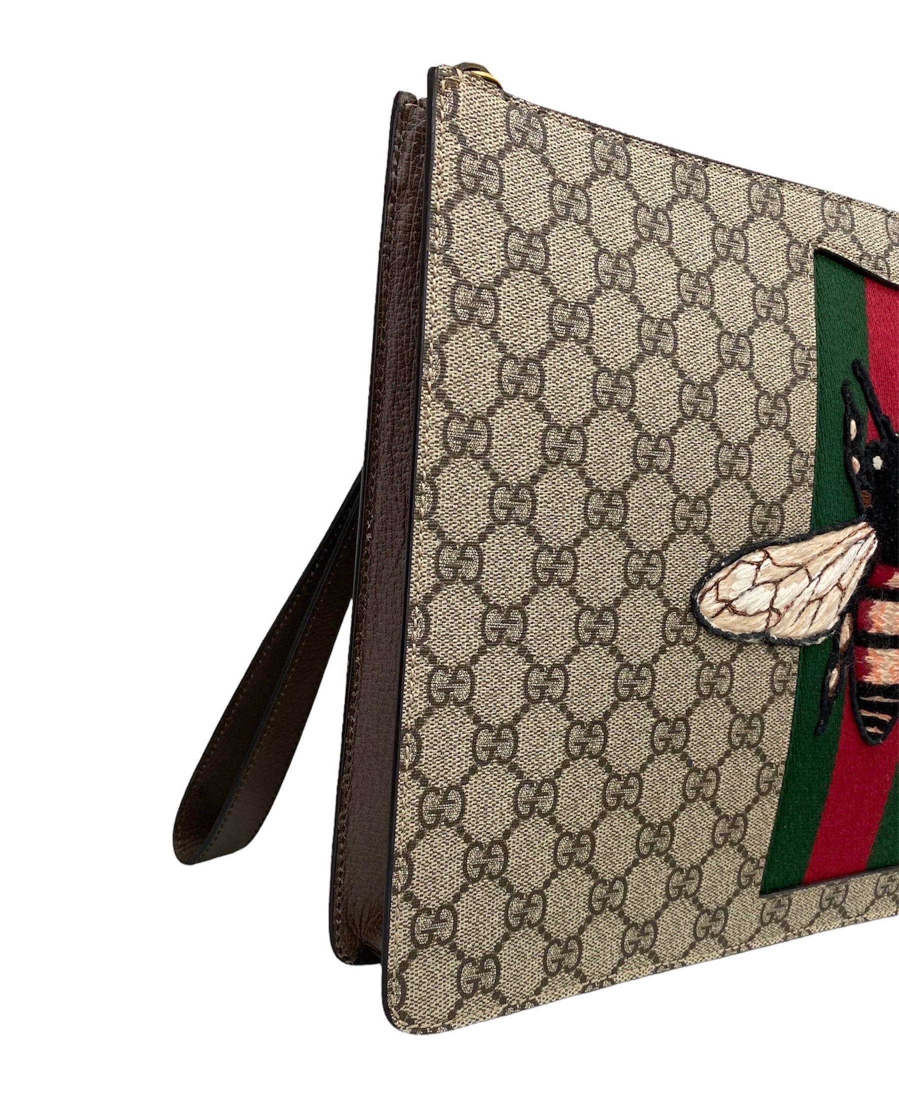 Gucci Handtasche aus GG Supreme Canvas und goldenen Beschlägen.

Die Vorderseite ist mit dem klassischen Gucci-Webband und einer Stoffbiene verziert.

Ausgestattet mit einer abnehmbaren Lederstulpe. Reißverschluss.

Der Innenraum ist geräumig
