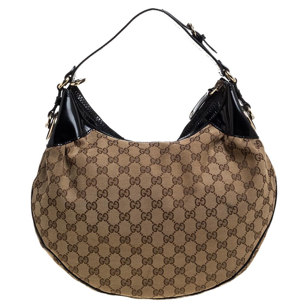 Diese trendige Full Moon Hobo von Gucci ist ein Kauf:: den Sie nicht bereuen werden. Die aus GG Canvas gefertigte und mit Lacklederbesätzen gestylte Tasche verfügt über ein geräumiges Innenfach aus Stoff und einen einzelnen Henkel:: mit dem Sie sie