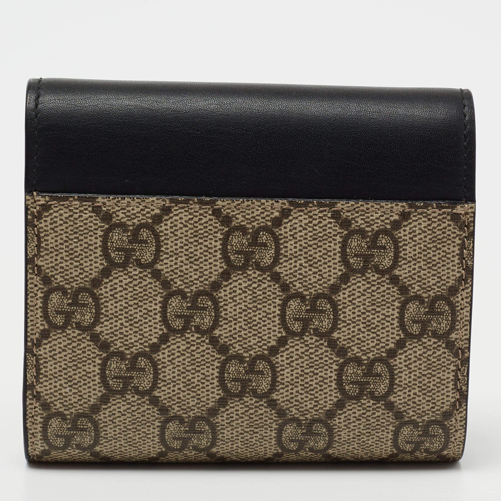Porta con te i tuoi oggetti di valore con stile e sicurezza grazie a questo portafoglio della Maison Gucci. Realizzata in tela e pelle GG Supreme nero-beige, con chiusura a lucchetto sul davanti. Presenta finiture dorate e un interno in tessuto e
