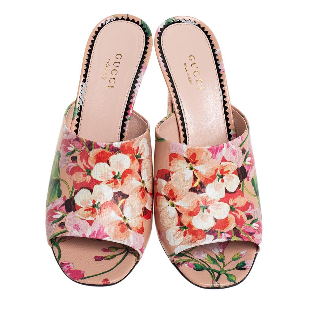 Gucci's timeless aesthetic and impeccable craftsmanship in shoemaking is evident in these stunning slide sandals. Crafted from leather in a beige shade, they feature broad straps accented with blooming floral prints. The sandals have been raised on