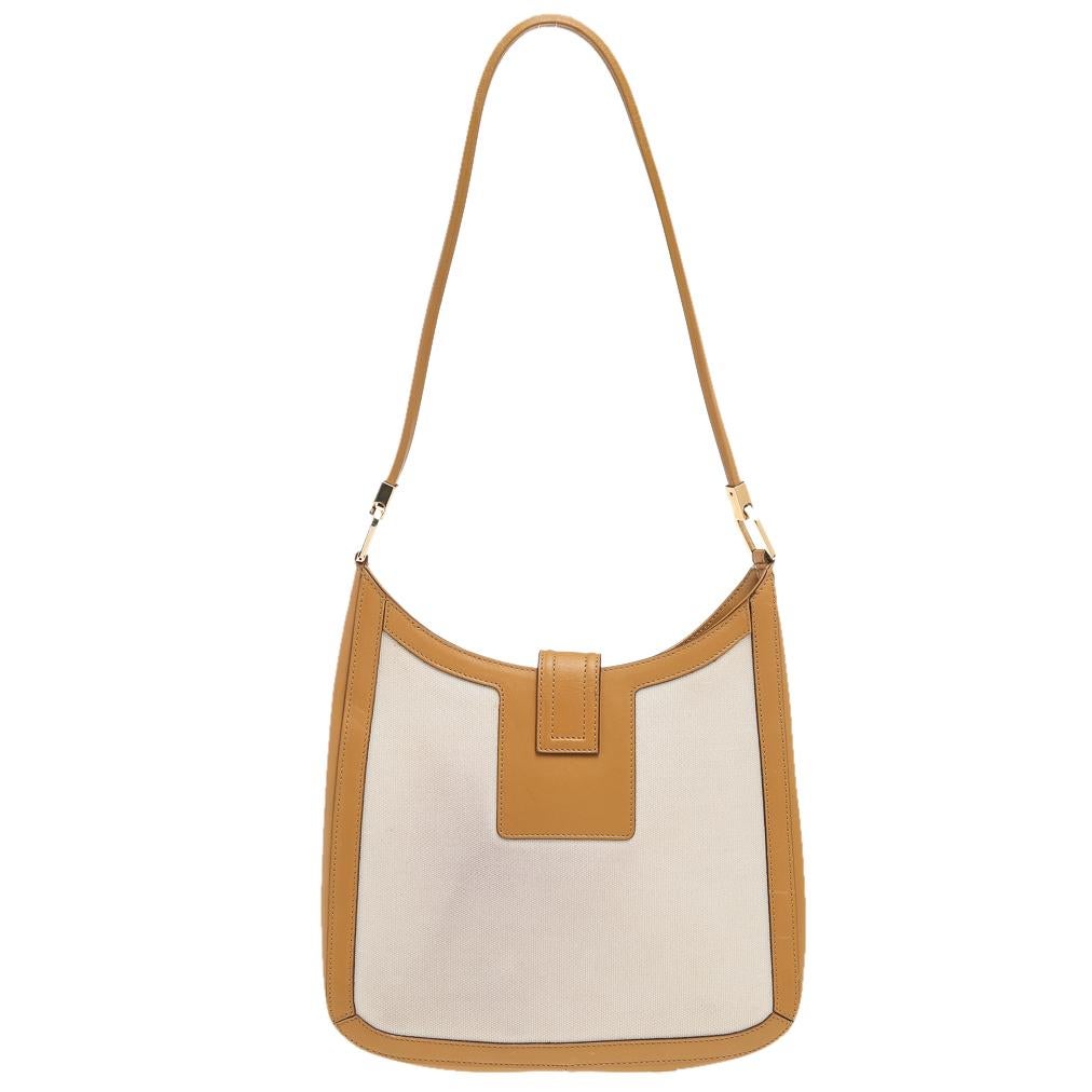 This impressive leather and canvas bag is gorgeous enough to uplift any look. The lining is well fitted and the exterior is smooth to touch. Crafted by the best, this Gucci creation lives up to its reputation. Made in beige & brown hues, this hobo