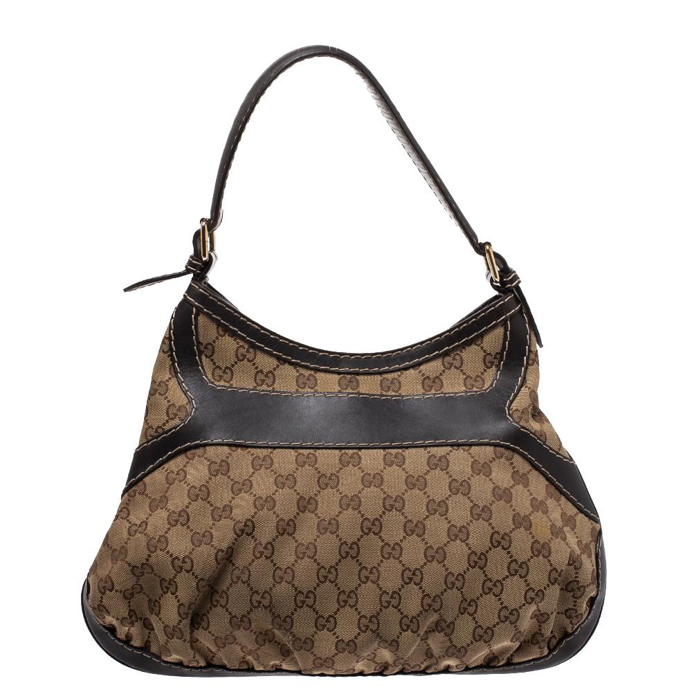 This Queen hobo comes from the iconic house of Gucci. Crafted in Italy and made from the brand's iconic GG canvas & leather, it comes in beige and brown hues. It is styled with a single shoulder strap, an exaggerated buckle detail in the front and