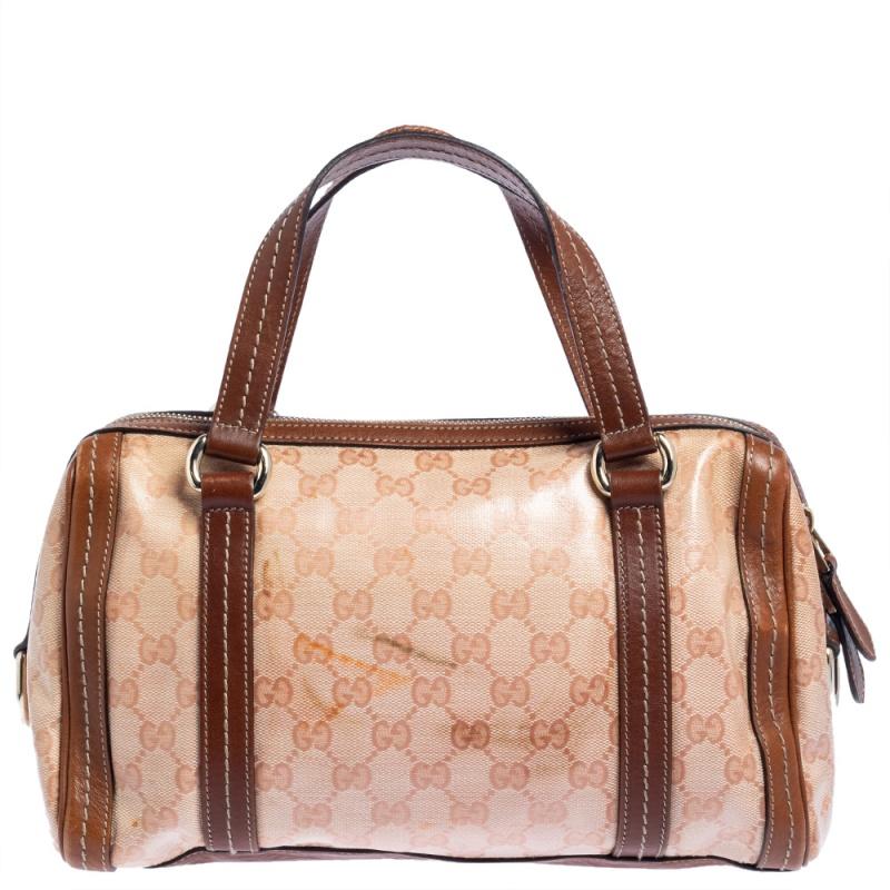 Achieve a refined look with the charming Duchessa satchel bag by Gucci. This handbag is crafted from GG crystal canvas with brown leather trims. This bag is accented with a large gold metal bow, a leather Gucci crest charm, side D rings, comfortable