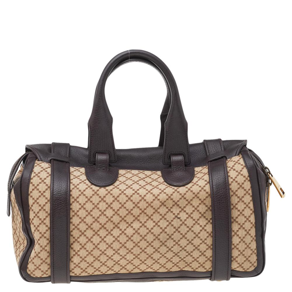 Looking for a perfect way to carry all your belongings together? The wait is over with this Boston bag from Gucci. This beautiful bag is created using brown-beige Diamante 73 canvas and leather. It is held by dual top handles and provided with a