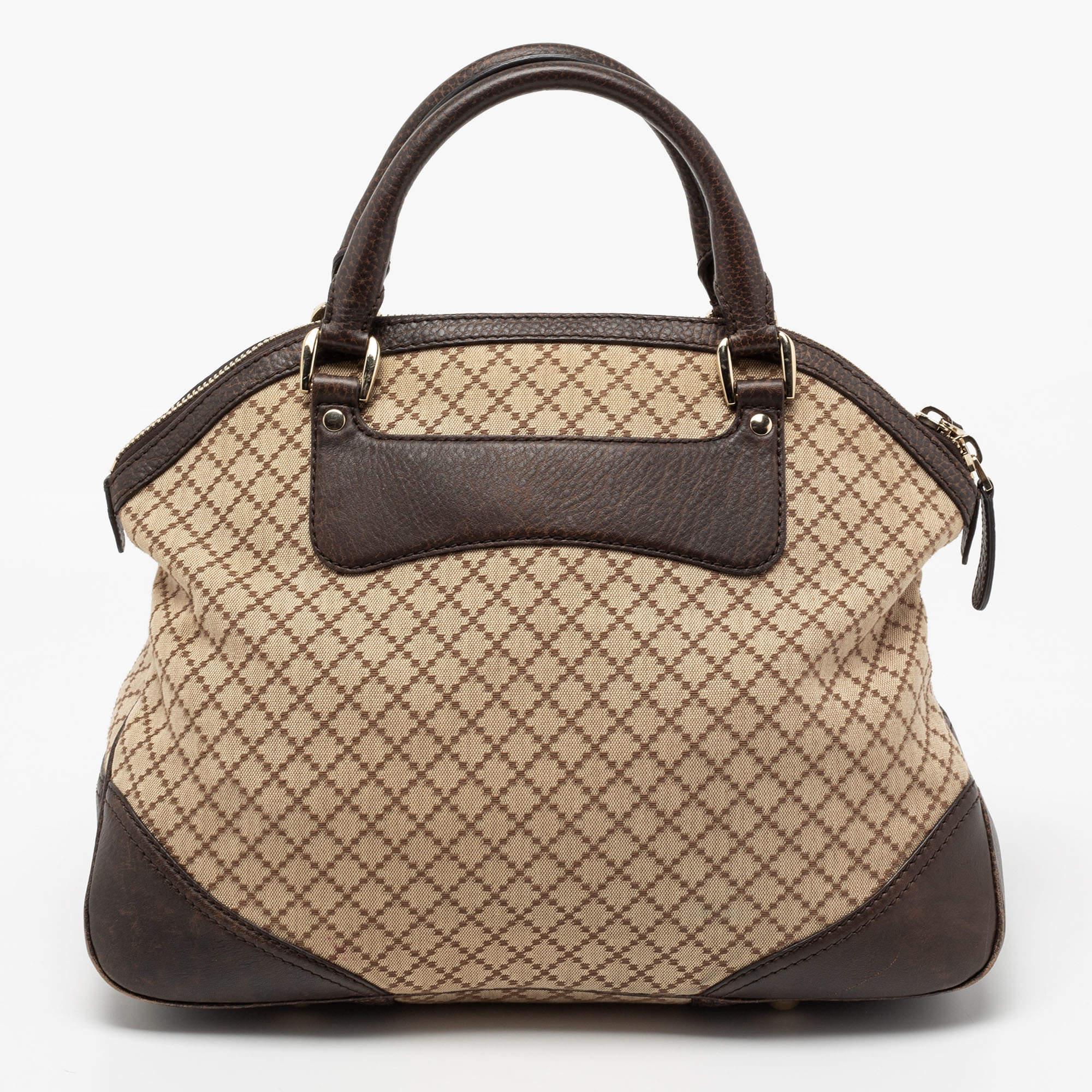This Gucci Catherine satchel is crafted from beige Diamante canvas and enhanced with brown leather. The bag features dual handles, and the signature Horsebit motif adorns its front. The top zip closure opens to a canvas-lined interior that houses