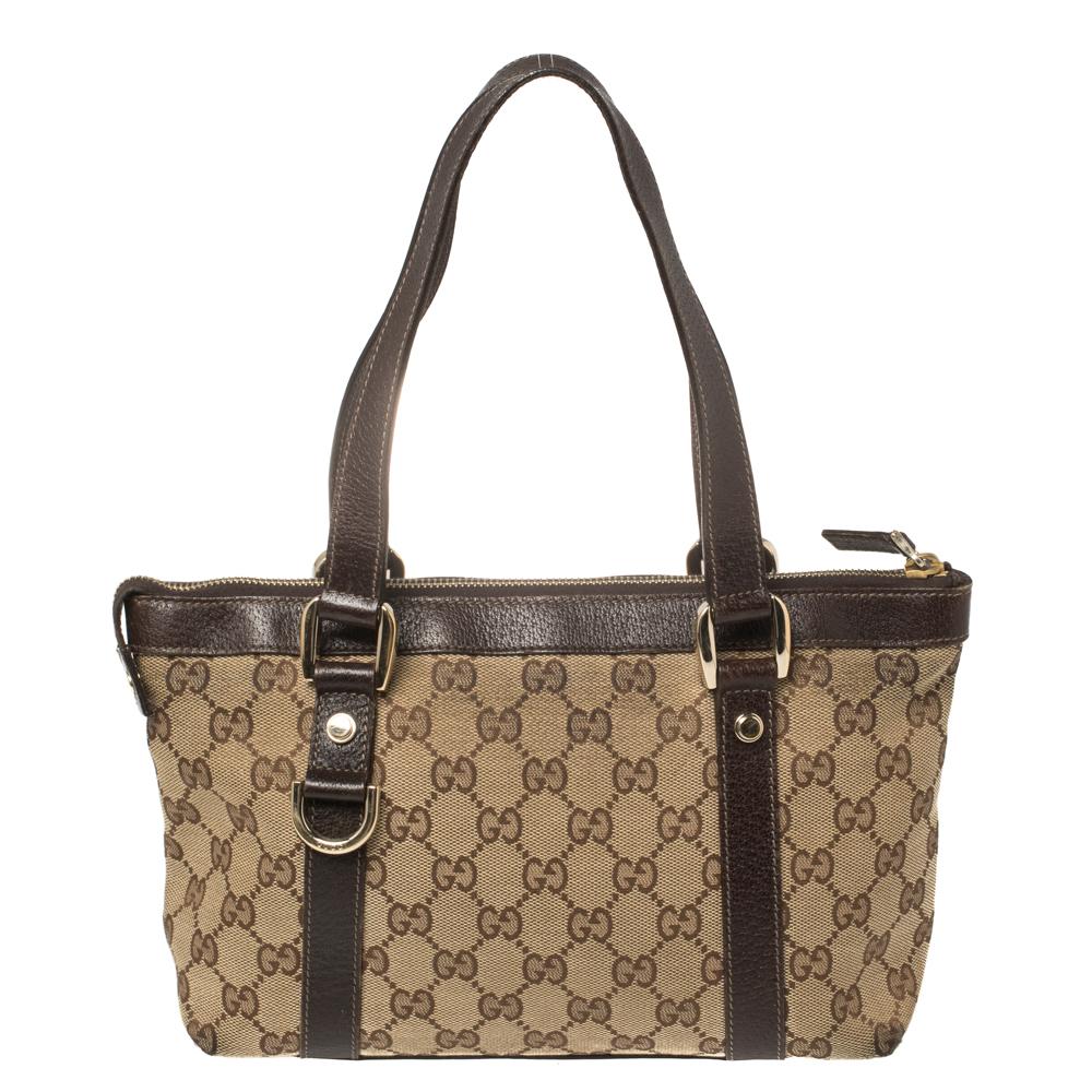 Gucci brings to you this amazing Abbey tote that is a classic. Made in Italy, this beige tote is crafted from the signature GG canvas and brown leather and features dual top handles. It flaunts gold-tone D-ring details on the front and back and