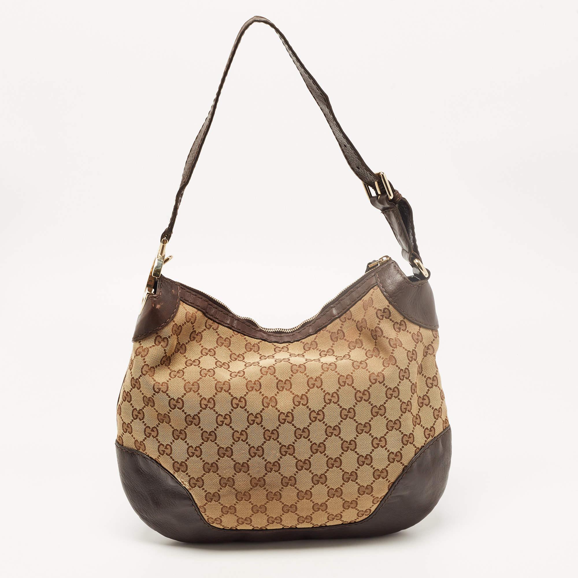 This Charlotte hobo from the house of Gucci will be your perfect everyday accessory. Crafted from classic GG canvas, it features a leather handle. It is secured with a top zip closure that opens to a spacious interior that can easily hold all your