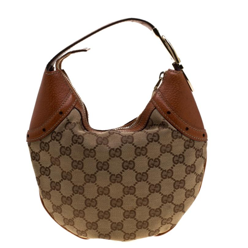 Complete a stylish look with this beautiful Gucci hobo. It is crafted from GG canvas as well as leather and the top-zip closure opens up to a fabric interior. This hobo is completed with a single belted handle. Perfect complement to all your