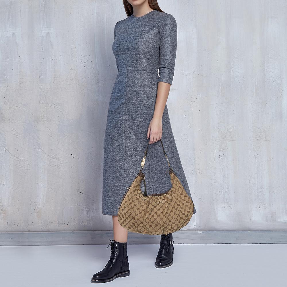 Eine Handtasche sollte nicht nur gut aussehen:: sondern auch langlebig sein:: so wie diese hübsche Twins Hobo von Gucci. Diese wunderschöne Tasche wurde in Italien aus beschichtetem Canvas und Leder von GG gefertigt und lässt sich mit einem