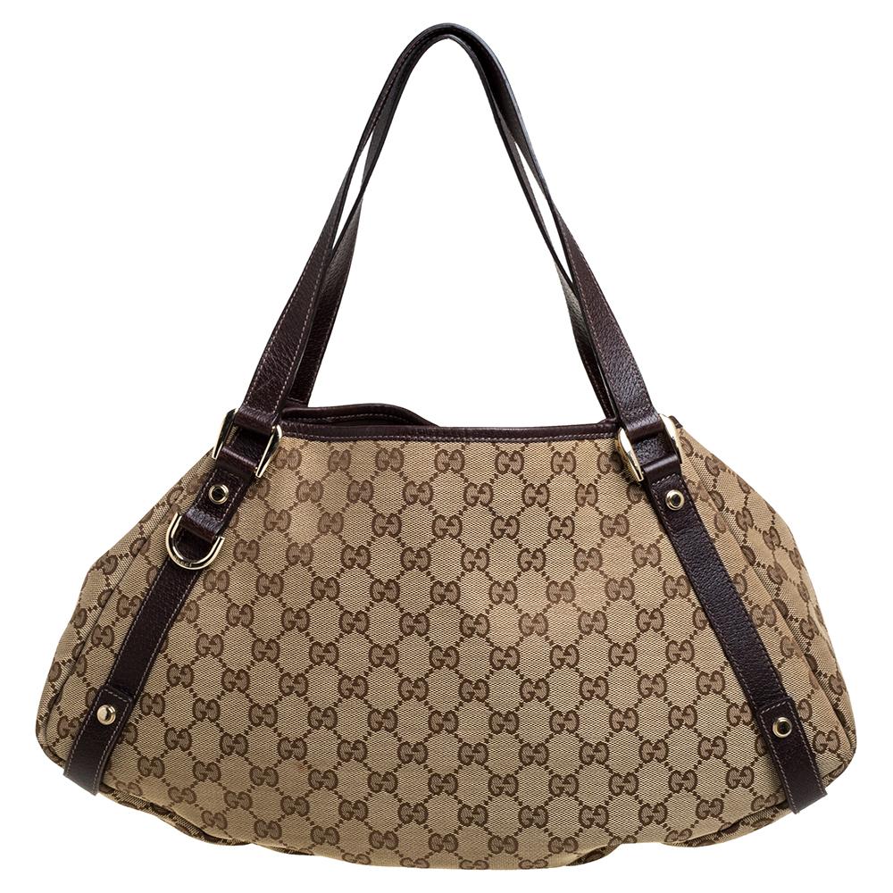 Gucci brings to you this amazing Abbey shoulder bag that is a classic. Made in Italy, this beige & brown creation is crafted from GG canvas and features leather handles. It opens to a fabric-lined interior with enough space to hold all your daily