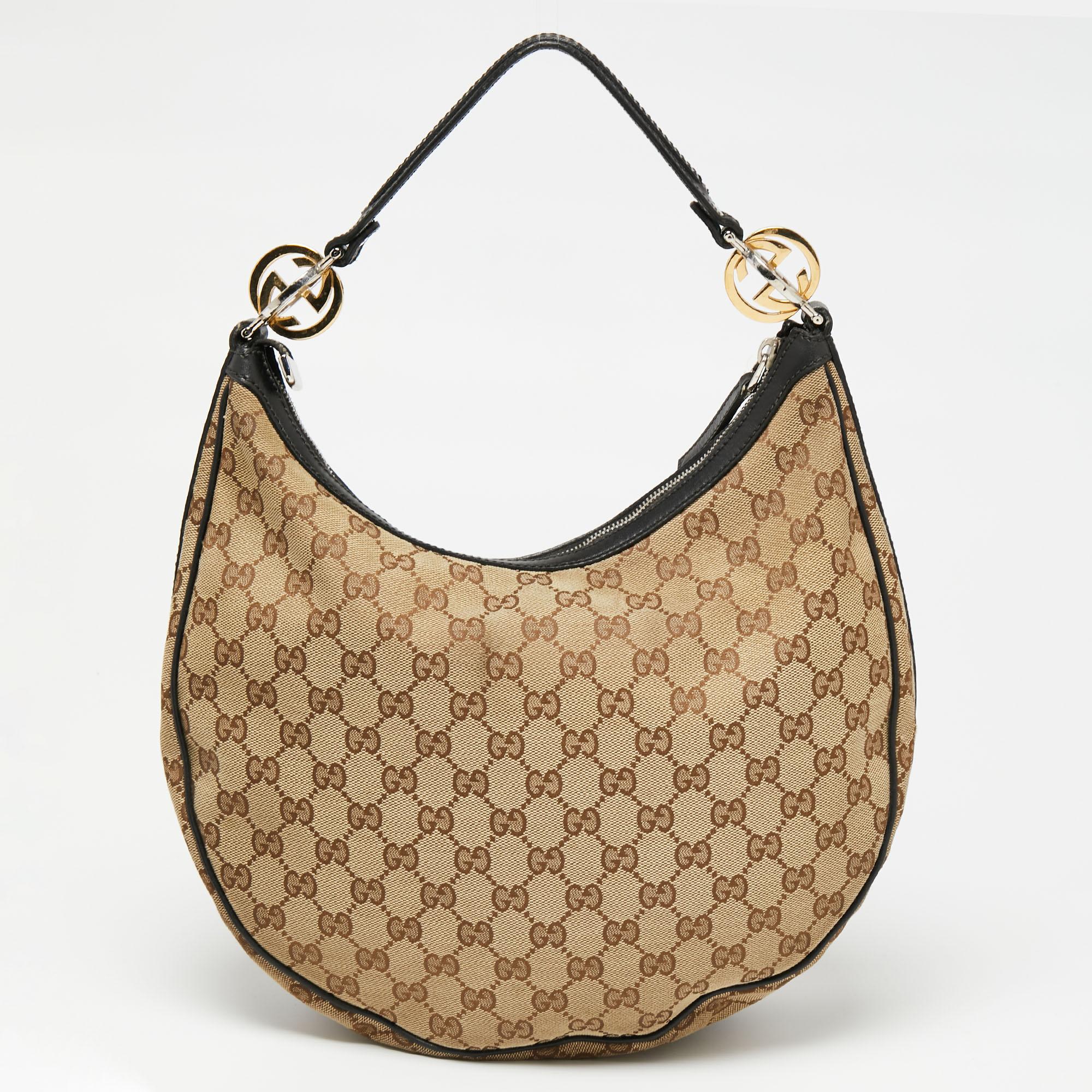 Chic and durable is this pretty GG Twins hobo from Gucci. Crafted from canvas and leather, this gorgeous bag has a top zip closure that opens up to a spacious fabric interior. Complete with a single handle that has the signature GG accents on its