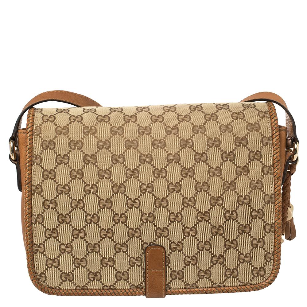 Carry your essentials in style in this medium Gucci Marrakech messenger bag. It has been crafted in a combination of brown leather and GG beige canvas. The flap features woven leather trim, and the double tassel with G detailing in gold-tone looks