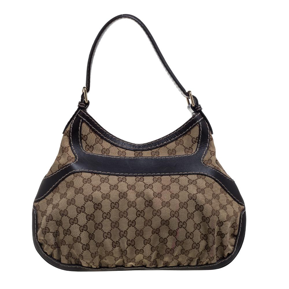 This Queen hobo comes from the iconic house of Gucci. Crafted in Italy and made from the brand's iconic GG canvas & leather, it comes in beige and brown hues. It is styled with a single shoulder strap, an exaggerated buckle detail in the front, and