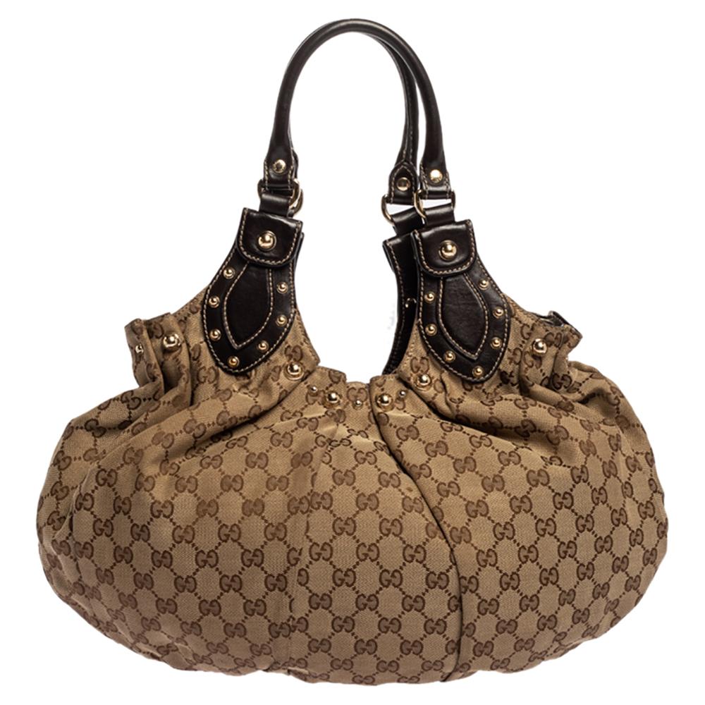 Take your style a notch higher with this Pelham hobo from Gucci. Cut out from GG coated canvas and leather, the bag features two leather handles, stud embellishments on the exterior, and a spacious fabric interior. This hobo is perfect for daily