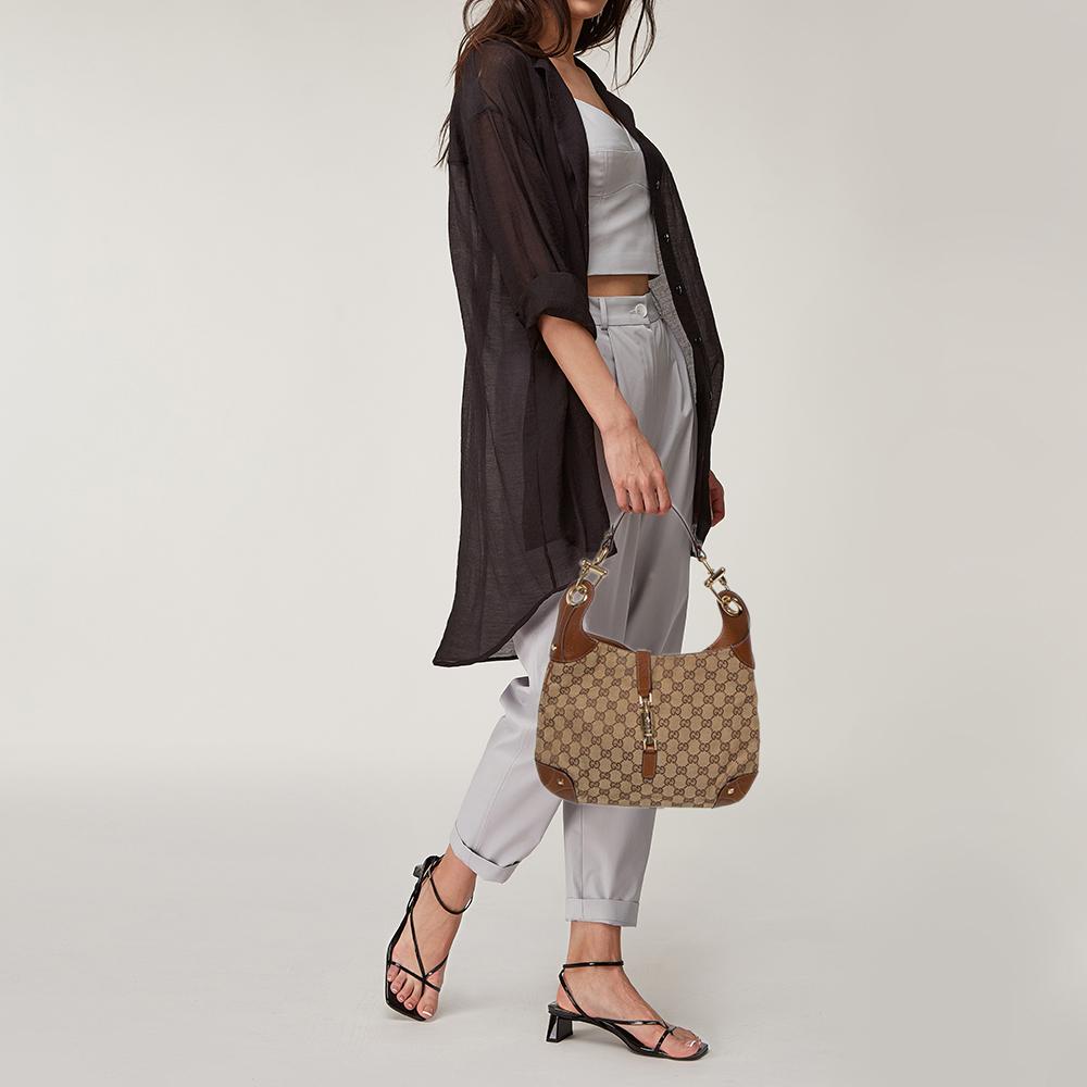Die gut verarbeitete und hübsch anzusehende Small Jackie Nailhead Hobo ist die perfekte Ergänzung zu Ihrer femininen Garderobe. Die Tasche ist aus GG-Canvas gefertigt und mit Lederbesätzen versehen. Sie verfügt über ein goldfarbenes Schloss:: das