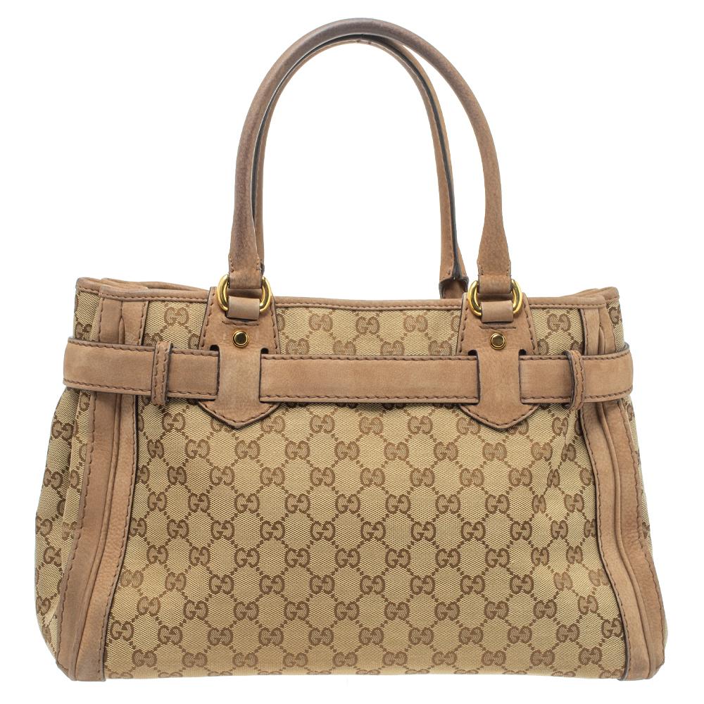 Add a touch of class to your everyday outfits with this Gucci Running tote. It features a GG canvas exterior trimmed with nubuck and is equipped with rolled top handles and a dangling tag on the front. The gold-tone GG logo buckle on the front