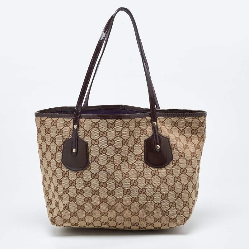 Crafted from GG canvas & patent leather, this tote by Gucci is of perfect size. Its beige & brown exterior is coupled with double handles and Gucci charms.

Includes: Dustbag