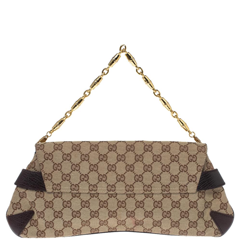 Expertly designed, flaunt a fashionable Gucci clutch this season. With a striking over-sized gold-tone Horsebit at the front flap, the bag is crafted in GG canvas. With an interlinked gold-tone chain strap, the bag is classy enough to tote around.

