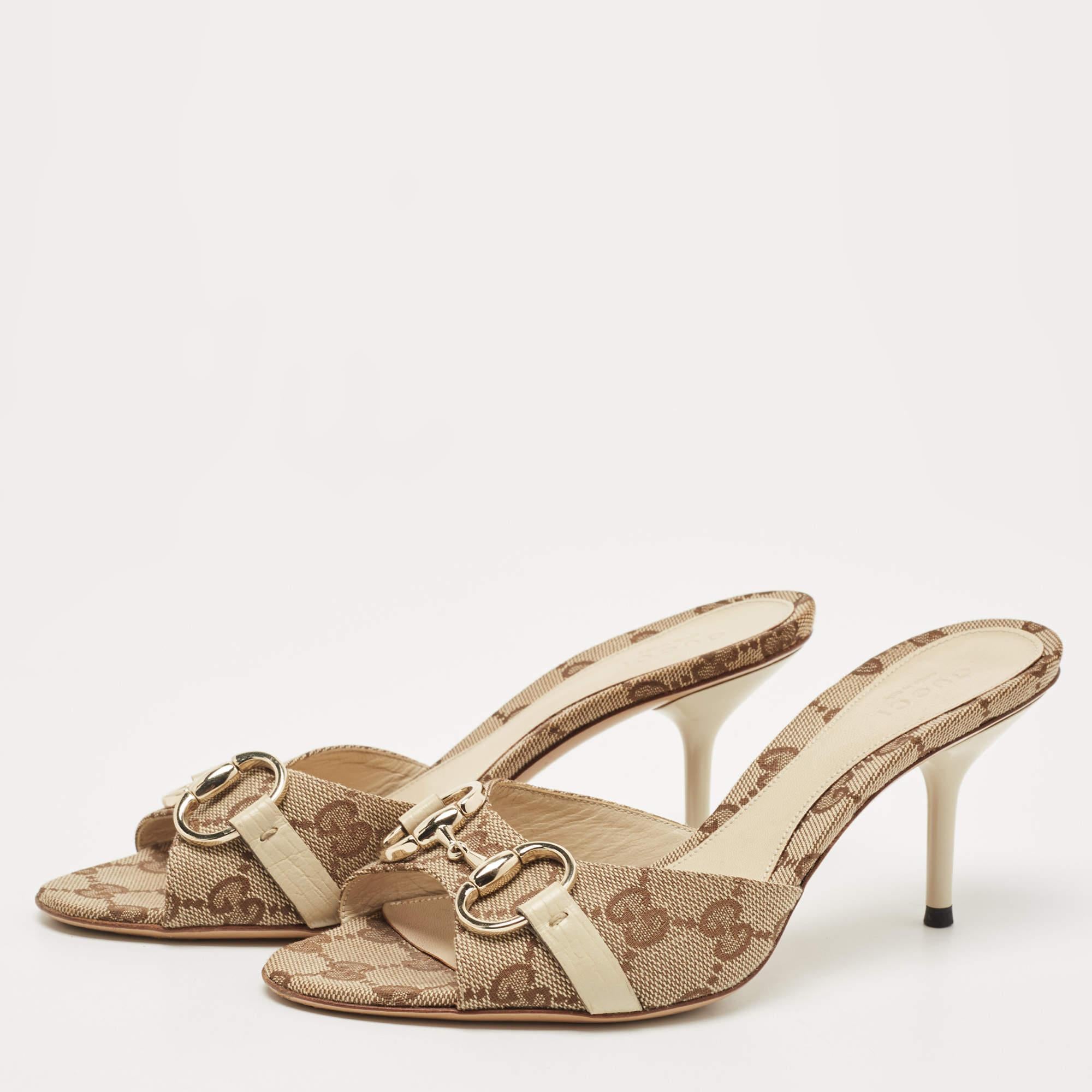 Gucci's timeless aesthetic and stellar craftsmanship in shoemaking is evident in these stunning slide sandals. Crafted from GG canvas, they are adorned with Horsebit accents held by leather straps. The high heels will raise your height in an