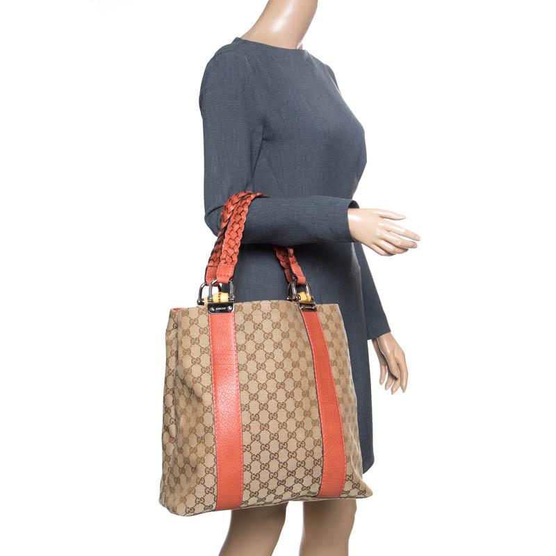 Light up your closet by owning this Bamboo Bar tote by Gucci. Crafted from signature GG canvas the bag features dual braided handles with bamboo details and leather trims. The fabric lined interior houses two open compartments divided by a zipped