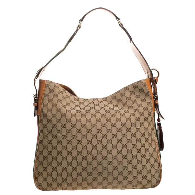 This stunning Heritage hobo by Gucci is a must-have. Crafted in Italy, it is made from the brand's signature GG canvas and leather. it comes in lovely shades of beige and brown. It is held by a single handle and features a canvas interior with a zip