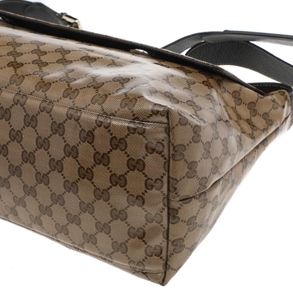 Displaying an impeccable design, this messenger bag from the House of Gucci is a wardrobe classic that definitely stands out! Rendered in brown-beige GG Crystal canvas and leather, this bag features a chic silhouette that is adorned with gold-toned