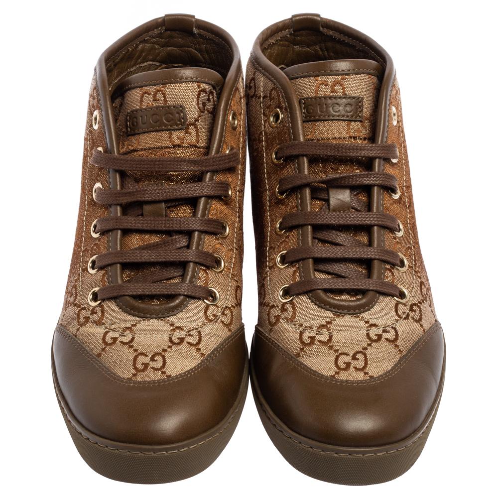 These high-top sneakers are made to offer instant style and comfort. Coming from the House of Gucci, these sneakers are made using beige-brown GG Monogram canvas and leather with lace-up details and a logo accent perched on the vamps. Gold-toned
