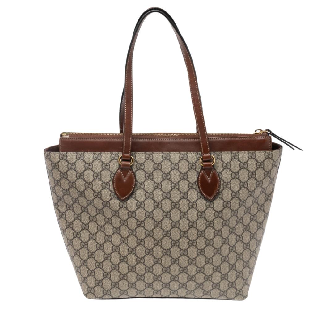 The tote from Gucci is a timeless piece. The bag comes in a luxurious combination of beige and brown hues with gold-tone hardware. It is crafted with GG supreme canvas and leather into a structured silhouette. This classic piece features double top
