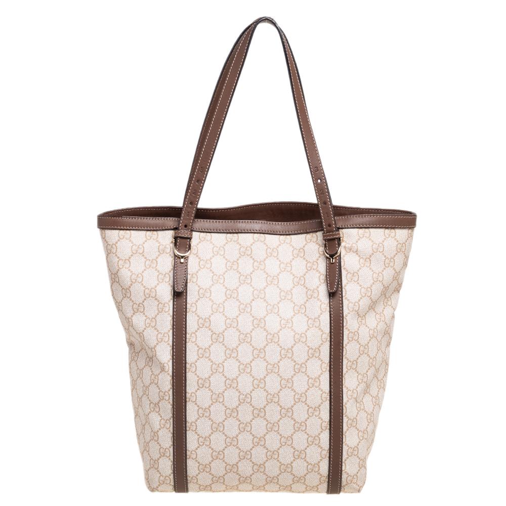 Gucci showcases a masterfully designed creation that is this beige and brown tote. Crafted from the signature GG Supreme canvas and leather, this everyday tote is equipped with a spacious interior and held by dual handles. A simple piece with a