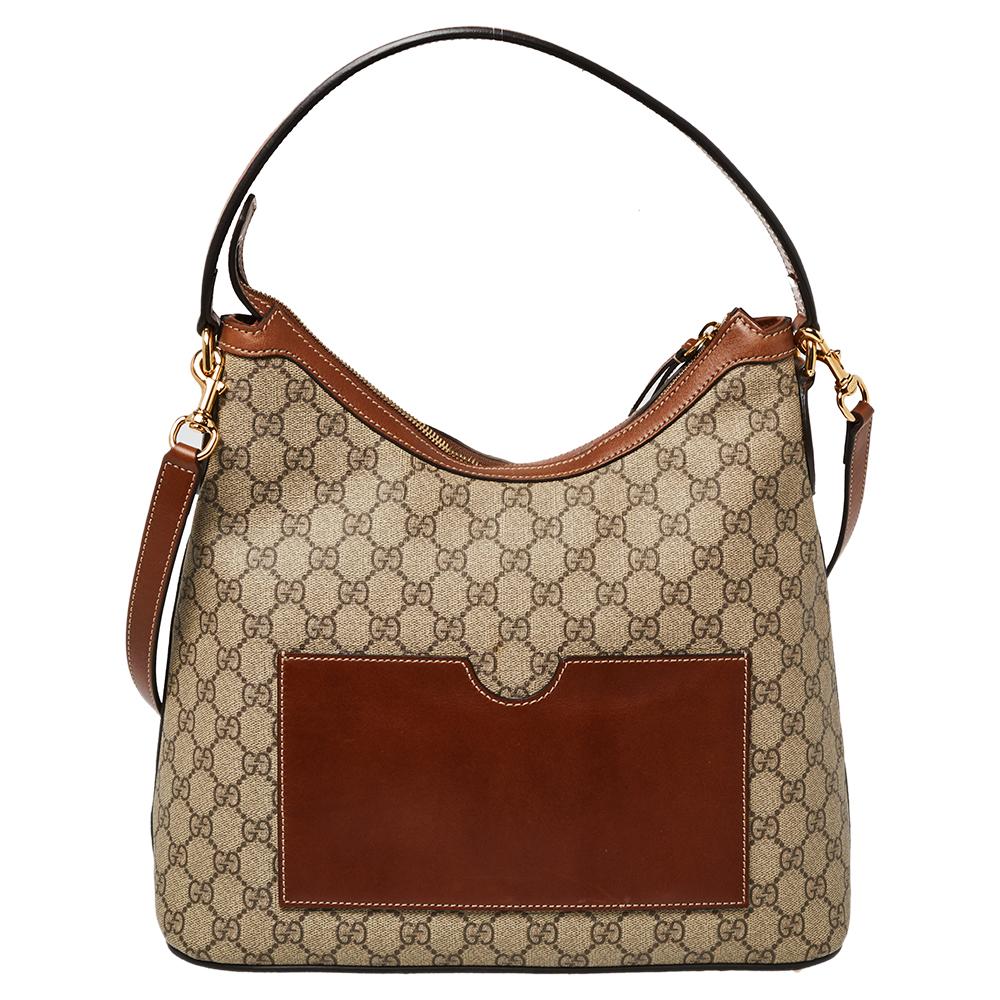 Gucci brings to you this amazing hobo that is a classic. Made in Italy, this beige and brown hobo is crafted from the signature GG Supreme canvas and leather and features a single top handle. It opens to an Alcantara interior with enough space to