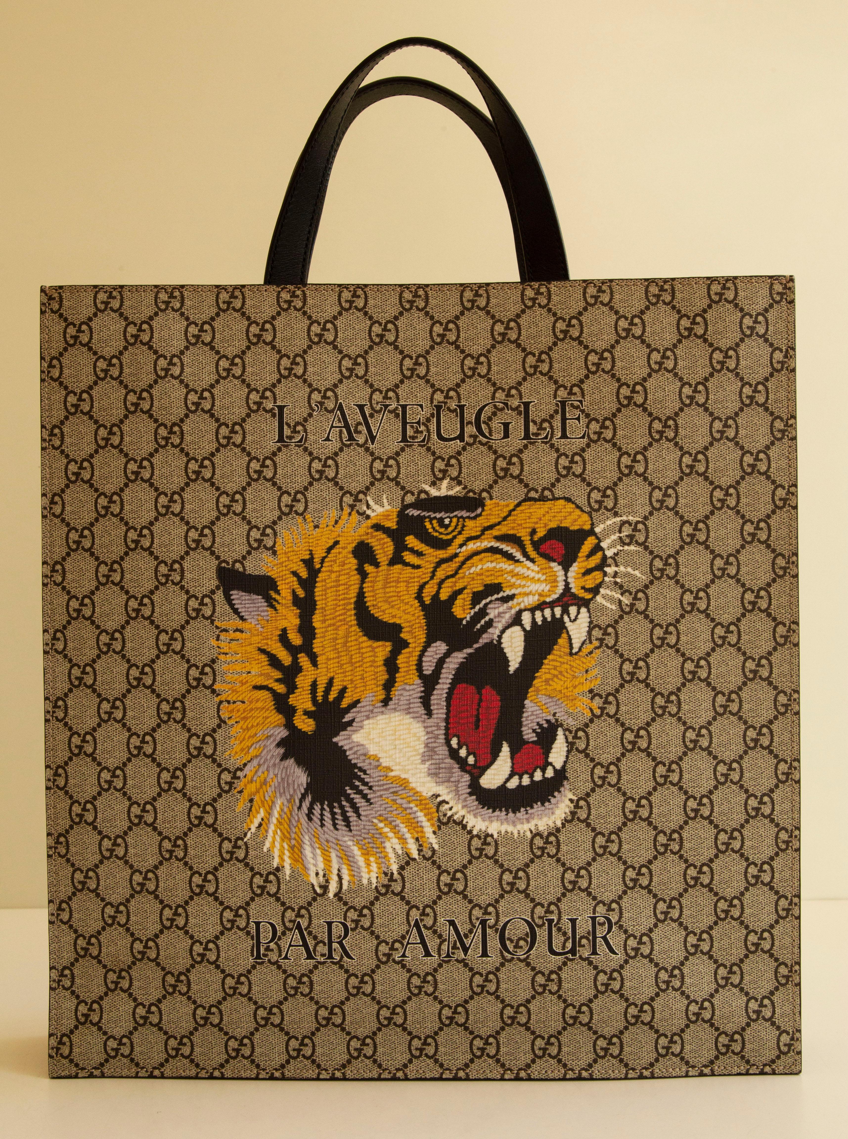 Gucci beige and brown GG Supreme Guccissima coated canvas with colorful tiger print tote bag. The interior consists of the main compartment with two large zipped pockets on each side. The bag can be worn by two top handles or as a shoulder bag width