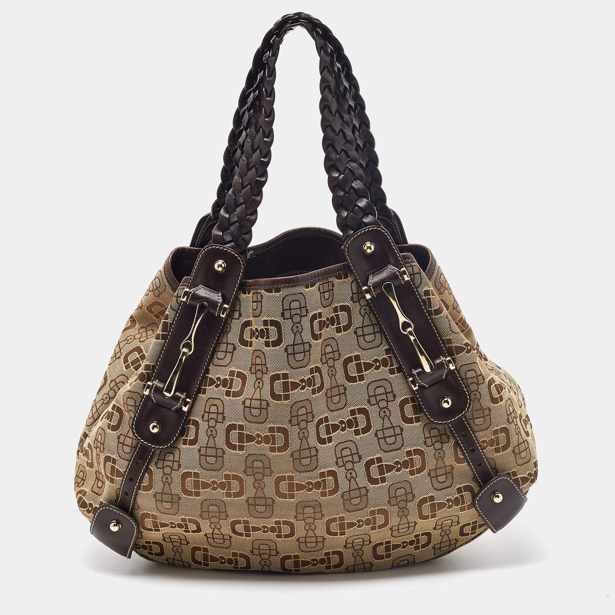 This Gucci Pelham bag for women comes fashioned with GG canvas and leather. It has a spacious size and durable construction. The designer bag is lined with fabric and held by two woven handles.

Includes: Original Dustbag

