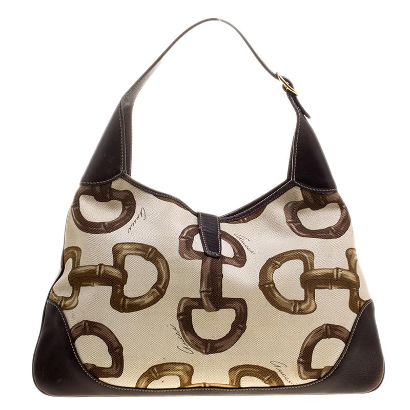 Complete a stylish look with this luxury Gucci hobo. It has been crafted from canvas and designed with the iconic Horsebit prints and a hook clasp. The top zipper leads way to a fabric interior and the bag is held by a single handle.

Includes:
