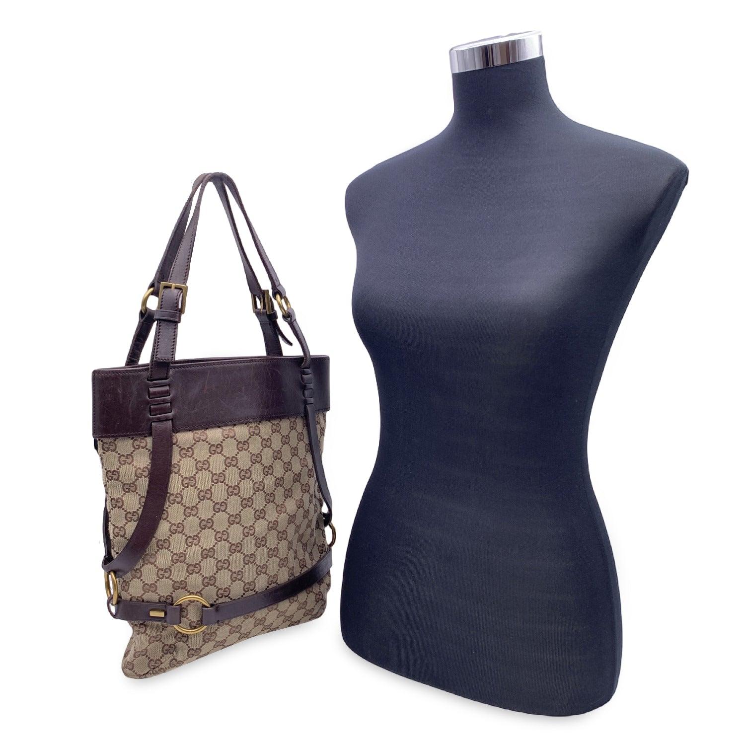 Effortlessly chic and unmistakably Gucci, this beautiful bucket/shoulder bag is crafted from classic beige monogram canvas and finished with rich brown leather trim. The open-top design offers both style and ease, revealing a supple brown leather