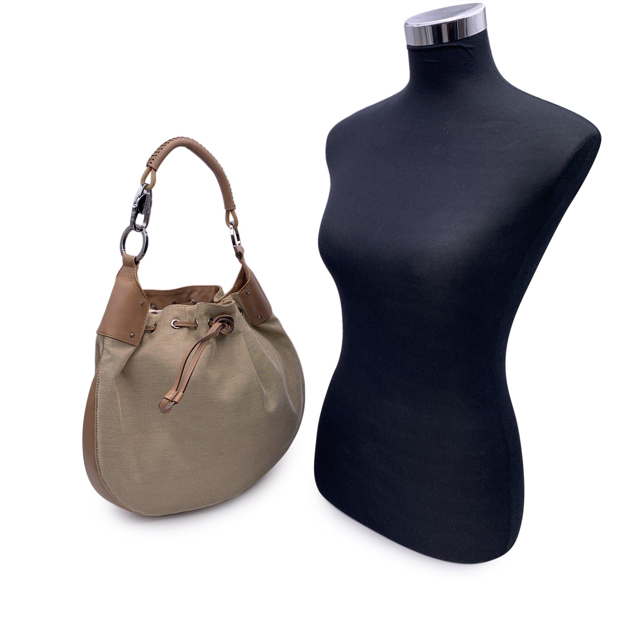 Beautiful Gucci hobo bag, crafted in beige canvas with beige leather trim and handle. Silver metal hardware. Drawstring closure. Brown canvas lining. 1 side zip pocket inside. 'Gucci - Made in Italy' tag inside (with serial number on its reverse).
