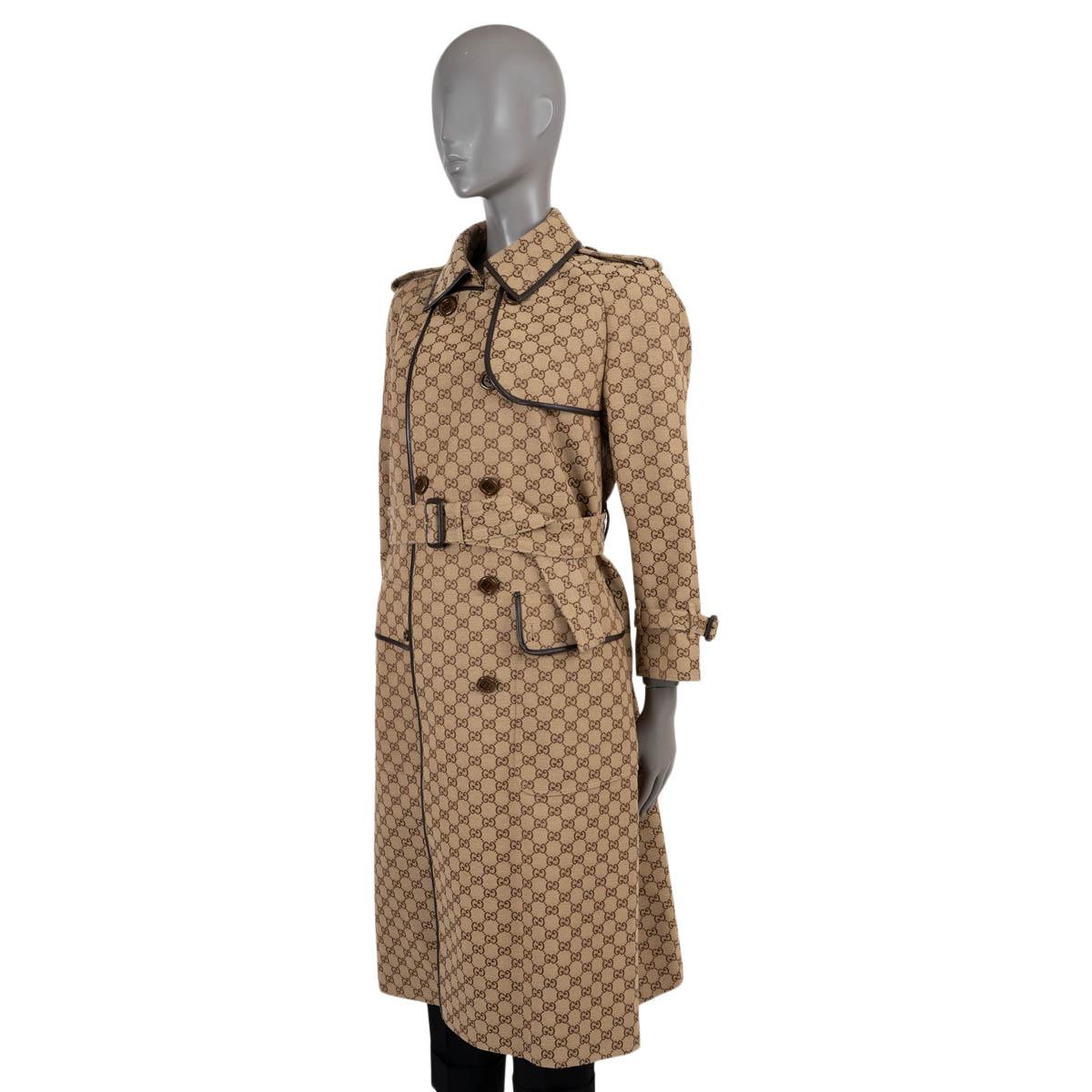 100% authentic Gucci trench coat in beige GG jacquard canvas cotton (71%) and polyester (29%). Features dark brown leather trims, spread collar, storm flap on the front and back, flap pockets, epaulettes, belted cuffs, belt loops and a matching belt