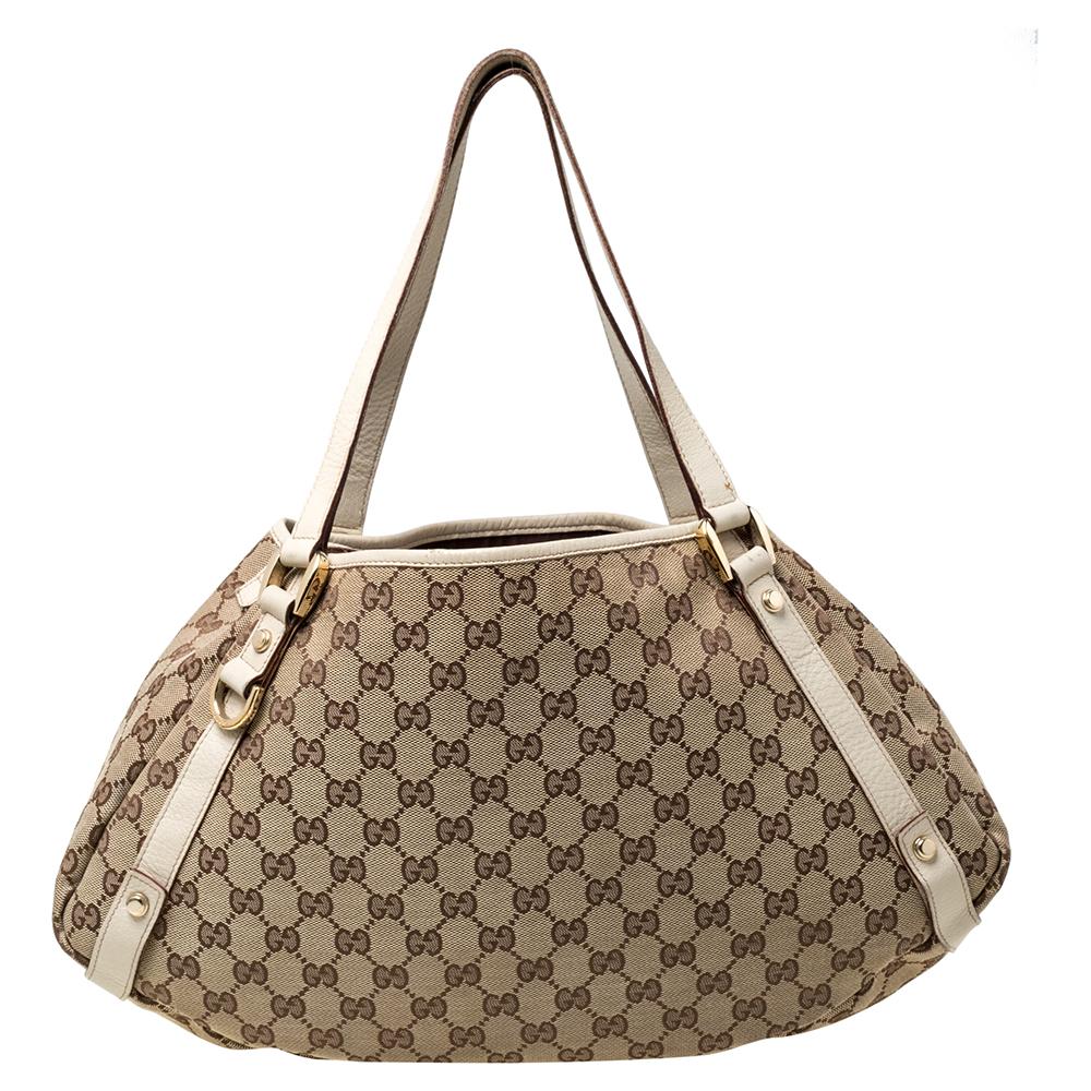 Gucci brings to you this amazing Abbey shoulder bag that is a classic. Made in Italy, this beige creation is crafted from GG canvas and features leather handles. It opens to a fabric-lined interior with enough space to hold all your daily