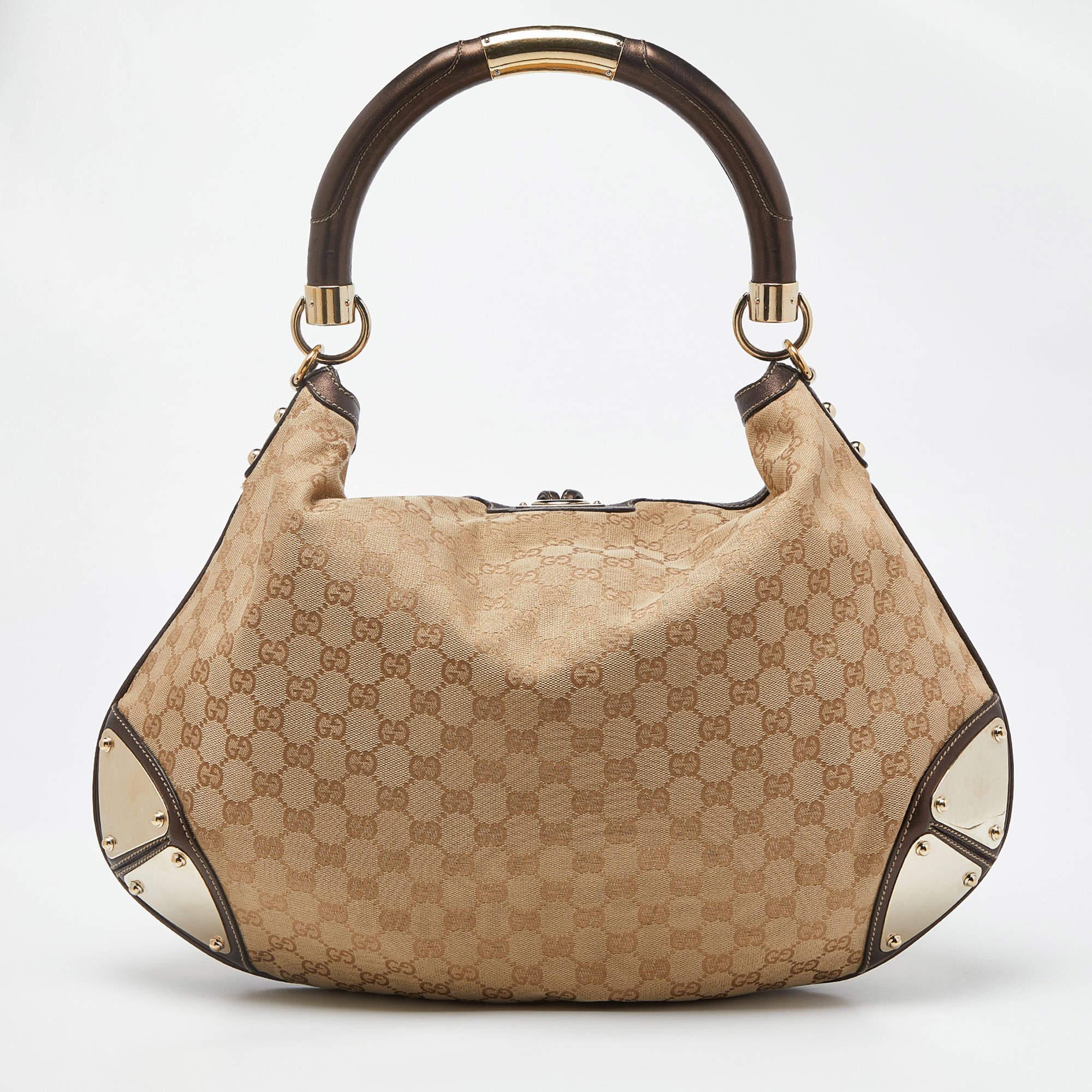 Crafted from GG canvas and leather, this Gucci number has a top with two bamboo-detailed tassels and a spacious fabric interior. It also features a sturdy top handle, armoured corners, and gold-tone hardware. Flaunt this beige & dark brown beauty