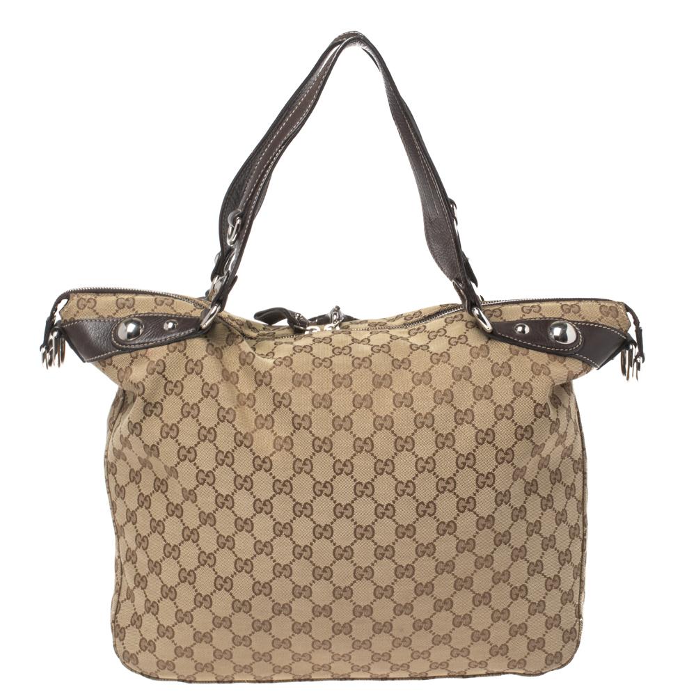 Diese Gucci-Tasche zeichnet sich durch exzellenten Stil und hohe Handwerkskunst aus und ist ideal für den täglichen Gebrauch. Sie ist aus GG-Canvas und Leder gefertigt und hat ein beiges & Ebenholzgehäuse mit Schutzfüßen an der Unterseite. Die