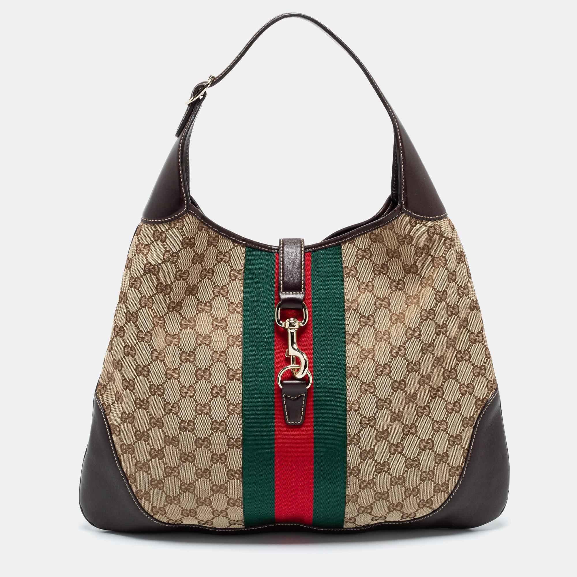 Iconic and captivating, this Jackie O Bouvier hobo comes from the House of Gucci. It has been crafted from beige-ebony GG canvas and leather, with a Web trim and lock closure embellishing the front. It features a single handle, a leather-fabric