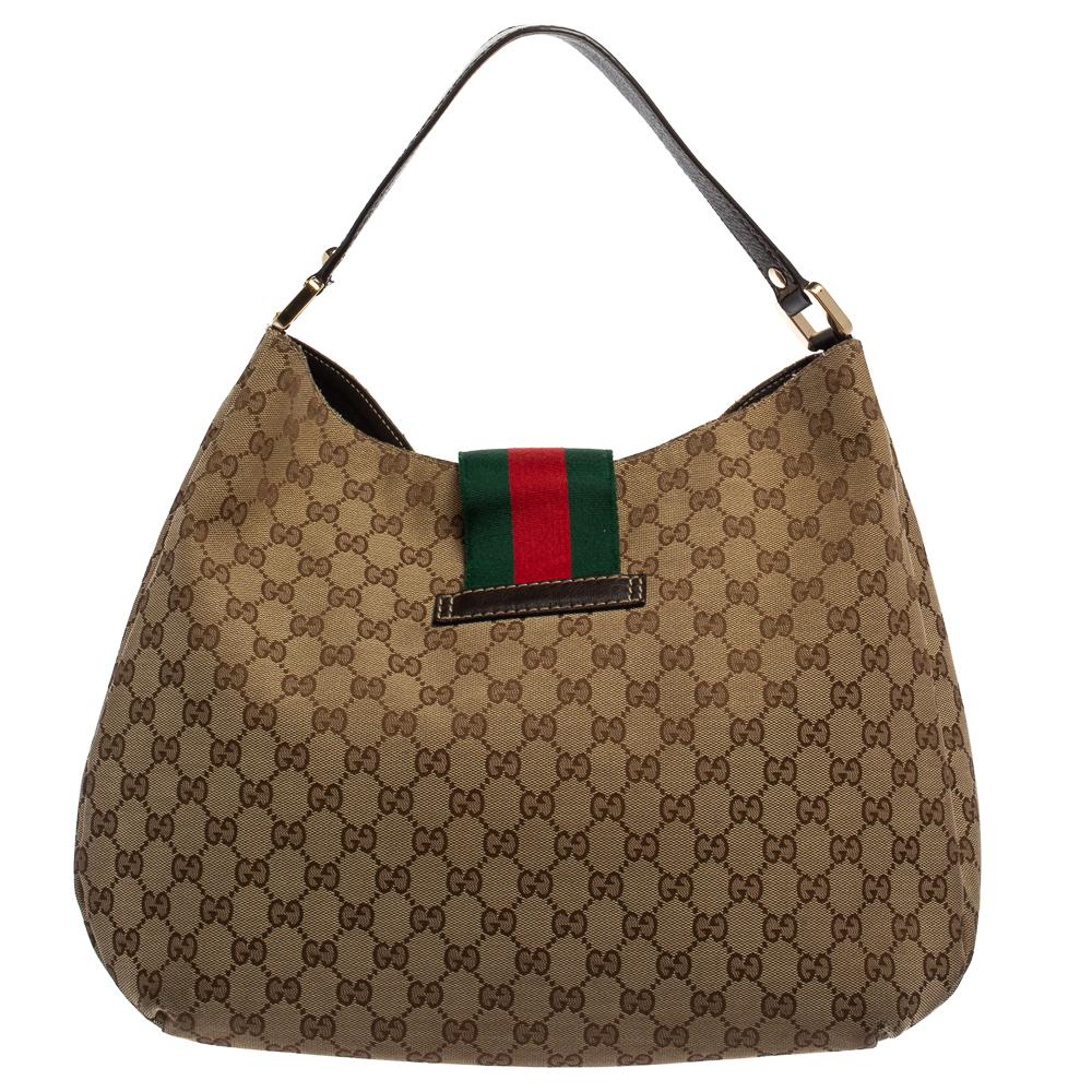 Crafted from GG canvas and leather in Italy, this gorgeous hobo from Gucci is a design that has never gone out of style. It has a flap styled as the House's iconic web stripe and it opens up to a spacious fabric interior. Held by a single leather