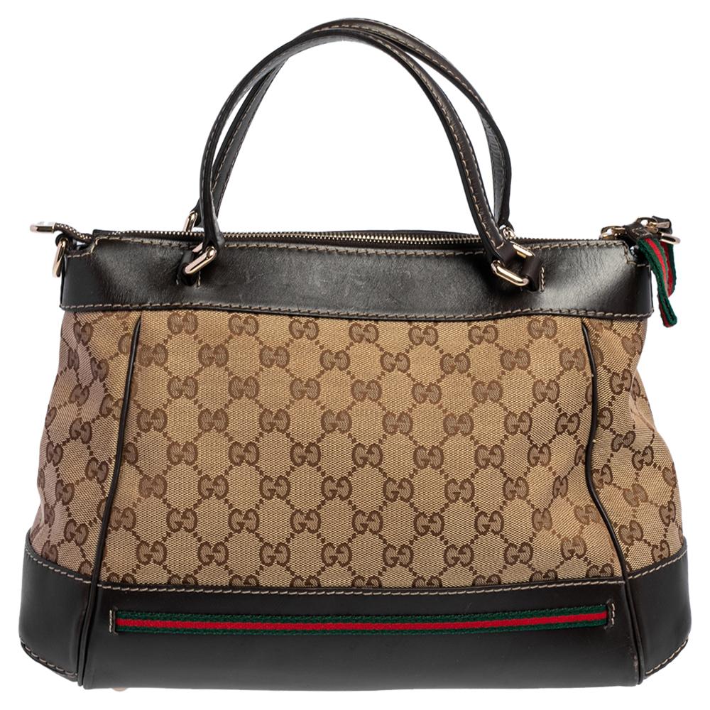Classic in appeal, beautiful in construction. This Mayfair Bow bag by Gucci is crafted from GG canvas as well as leather and styled with their signature Web trim. It features a top zip closure, dual handles, and a spacious canvas-lined interior to