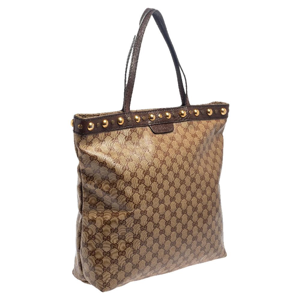 Known for its high standard and fine finish, this handbag will be your companion for years to come. This gorgeous Gucci Babouska tote is made from beige and ebony GG Crystal canvas that is a signature of the brand. It features dual flat handles,