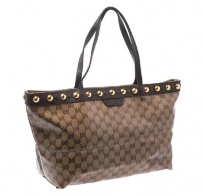 Known for its high standard and fine finish, this handbag from will be your companion for years to come. This gorgeous Babouska Tote from Gucci is made from beige and ebony GG Crystal canvas that is a signature of the brand. It features dual flat