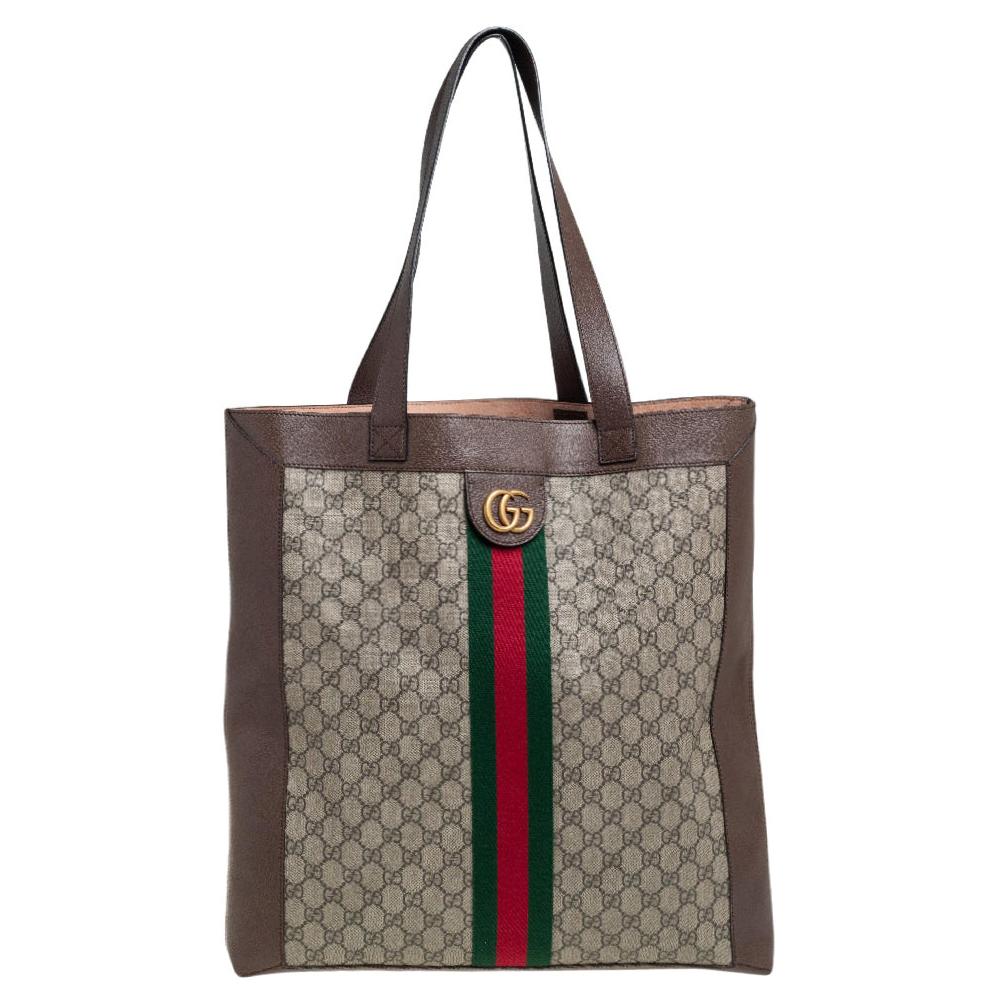 Add to your look by accessorizing with this Gucci Ophidia tote. Designed expertly, this bag features a GG Supreme body that is enhanced with leather trims. The bag flaunts the signature Web stripe and GG logo on the front and two top handles. It is
